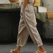 FJØRNA women's linen summer trousers with high waist and tapered fit, showcasing breathable, lightweight fabric in a natural pose.