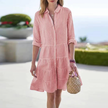 FJØRNA women's striped tiered summer mini dress hanging on a hanger, showcasing its casual, lightweight design and colorful pattern.