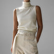 FJØRNA sleeveless wool vest for women, soft knit top, natural beige color, close-up of the fitted sleeveless design.