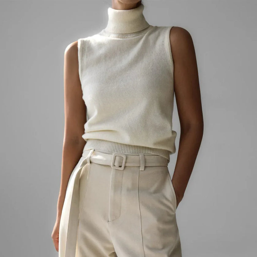 FJØRNA sleeveless wool vest for women, soft knit top, natural beige color, close-up of the fitted sleeveless design.