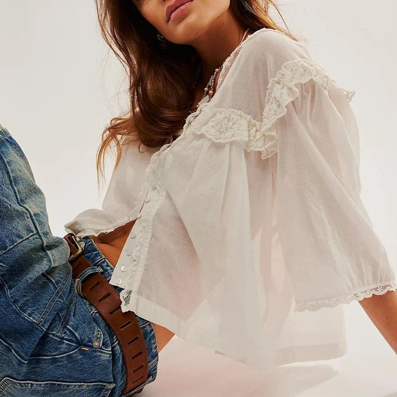 FJØRNA women's cotton blouse with ruffle detail, showcasing a stylish top with delicate ruffles and a soft fabric finish.