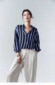 Lacceti Maren Stripe Satin Blouse featuring a relaxed fit, with white and navy stripes, long sleeves, and a silky satin finish.