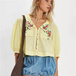 FJØRNA women's embroidered crop top with detailed floral embroidery, short sleeves, and a fitted style.