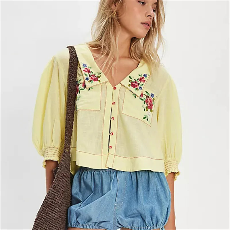 FJØRNA women's embroidered crop top with detailed floral embroidery, short sleeves, and a fitted style.