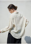 Light beige linen women's shirt from FJØRNA, featuring a relaxed fit, long sleeves, and button-up front.