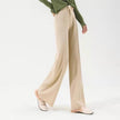 FJØRNA women's merino wool wide-leg high-waist trousers hanging on a rack, showcasing soft, comfortable fabric and stylish fit.
