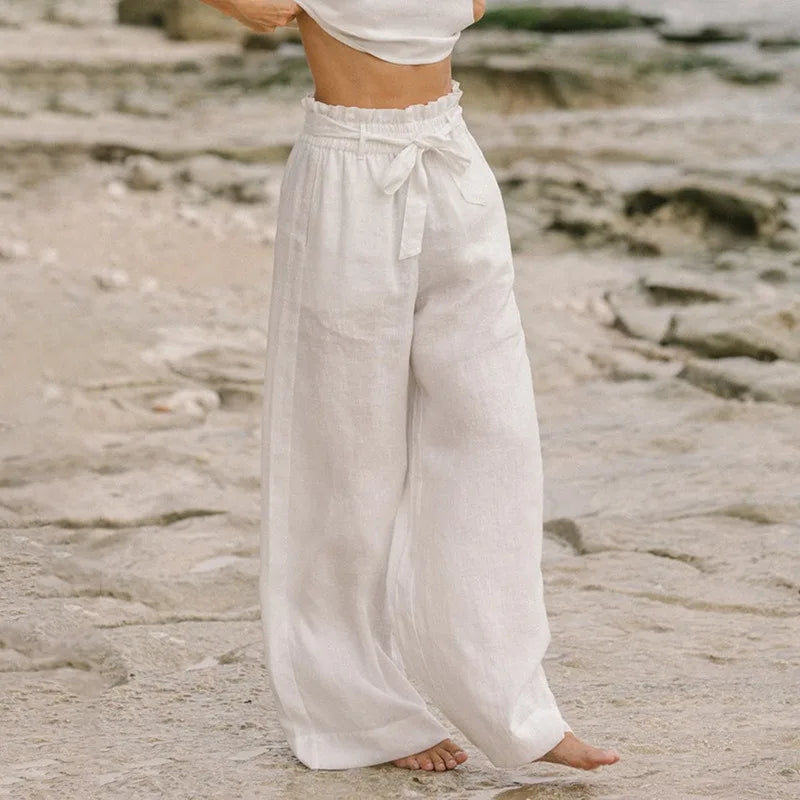 FJØRNA women's linen wide leg trousers with elastic waist and ruffle details, showcasing the relaxed, flowy fit and lightweight fabric.