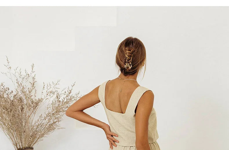 FJØRNA women's linen wide-leg trousers with elastic waist and ruffle details, shown in a relaxed fit on a model.