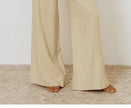 FJØRNA women's linen wide-leg trousers with elastic waist and ruffle detail, relaxed fit and lightweight fabric.