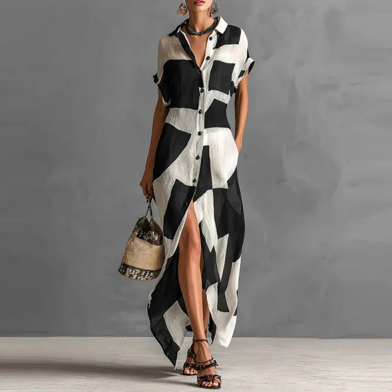 FJØRNA Victoria printed button-down maxi dress in white with floral pattern, flowing fabric, and long sleeves.