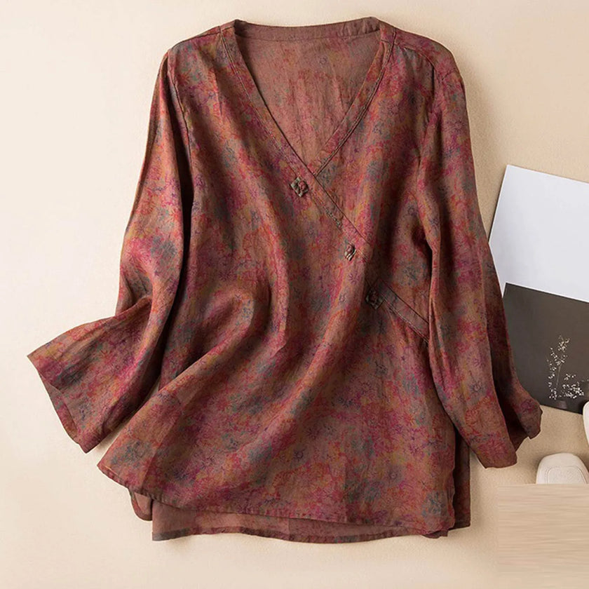 FJØRNA Kaien wrap-style blouse in soft fabric, featuring a V-neck and long sleeves, displayed on a hanger.