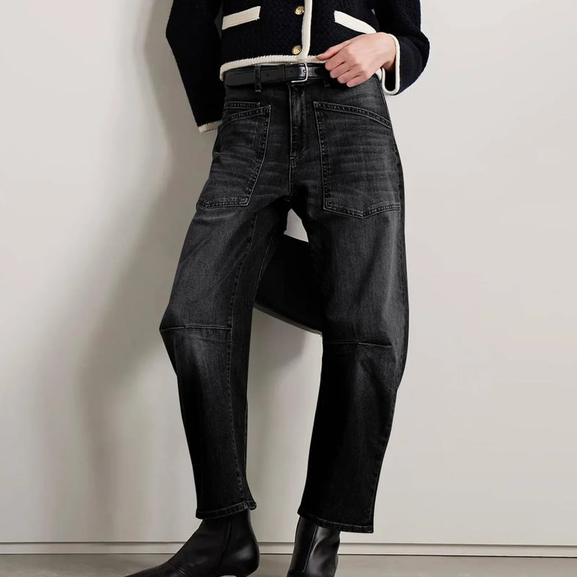 FJØRNA women's denim jeans with a barrel leg fit, showcasing classic blue denim with a relaxed, stylish silhouette.