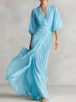 Powder blue FJØRNA dress with flowing fabric and elegant design, displayed on a hanger against a neutral background.