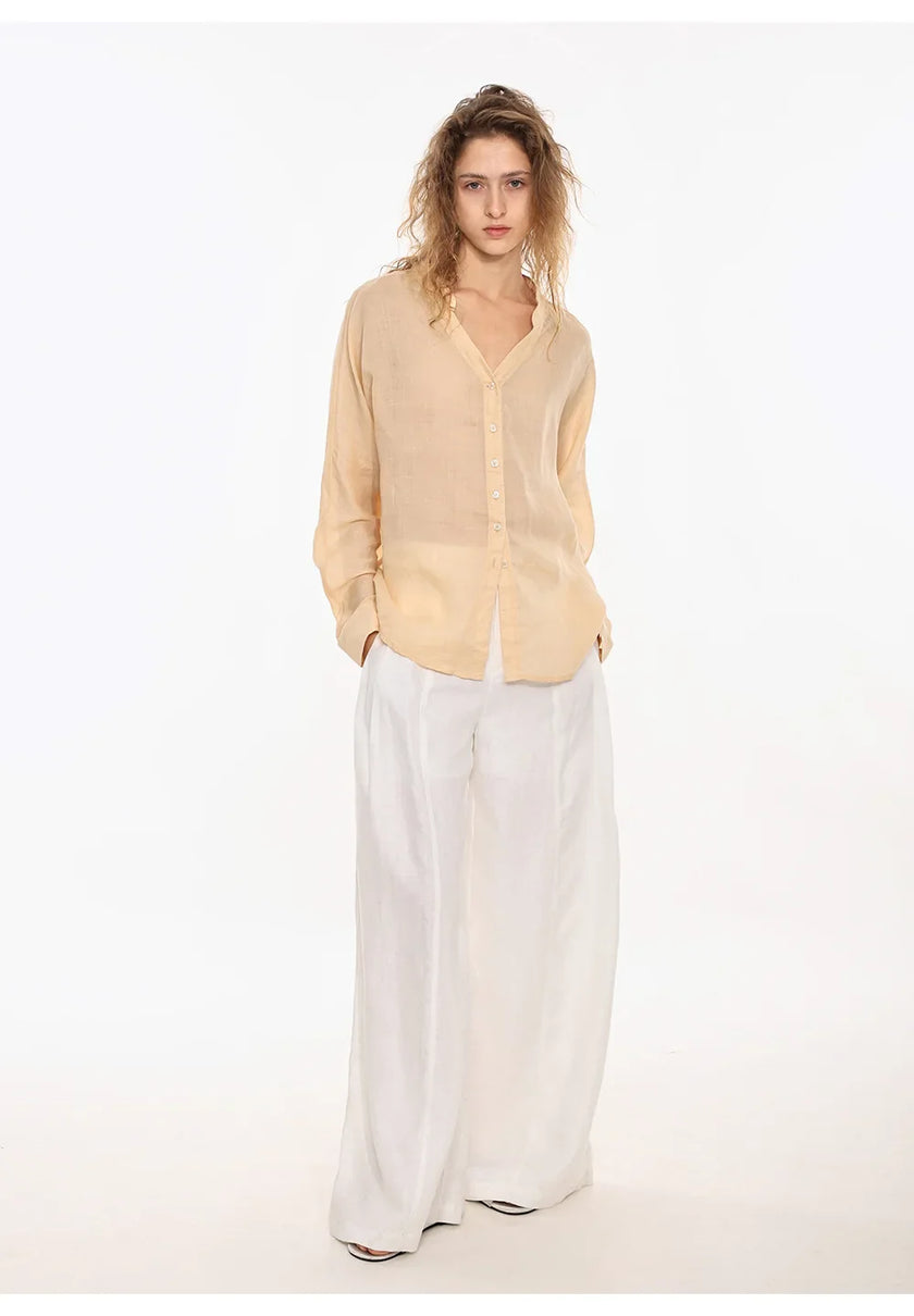Light beige linen women's V-neck shirt from FJØRNA, featuring a relaxed fit and soft, breathable fabric, displayed on a hanger.