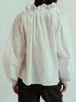FJØRNA women's cotton blouse with ruffle detail, showcasing a lightweight, stylish top with flowing fabric and feminine design.