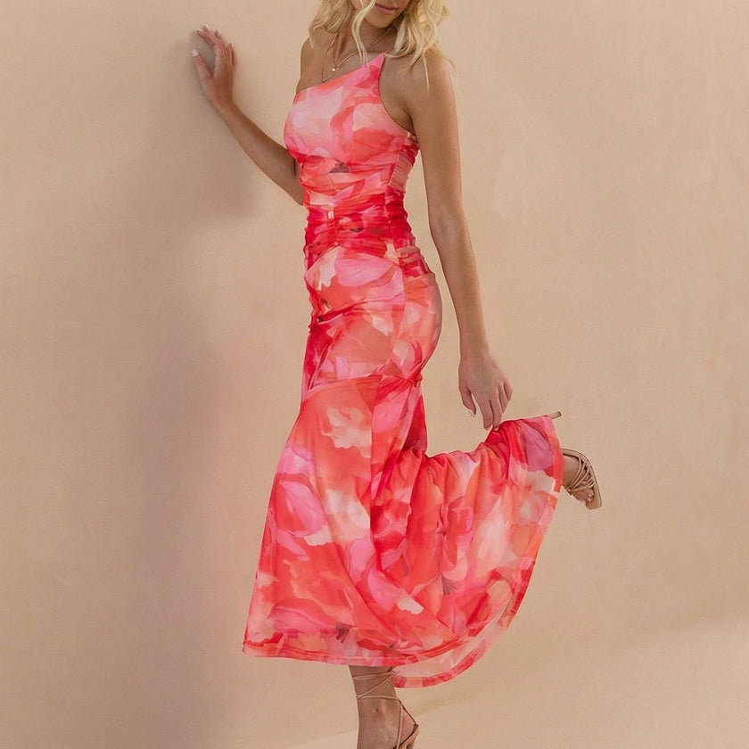 Side view of FJØRNA fitted one-shoulder maxi dress with mesh overlay and ruched detail, showcasing elegant design and silhouette.