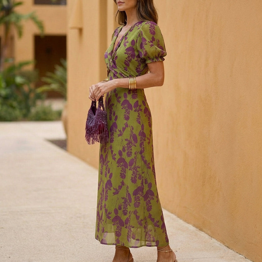 FJØRNA A-line wrap front maxi dress with V-neck, shown from the side, featuring flowing fabric and elegant silhouette.