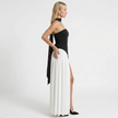 Side profile of a women's black and white strapless maxi dress by FJØRNA, showcasing elegant, flowing fabric and fitted bodice.