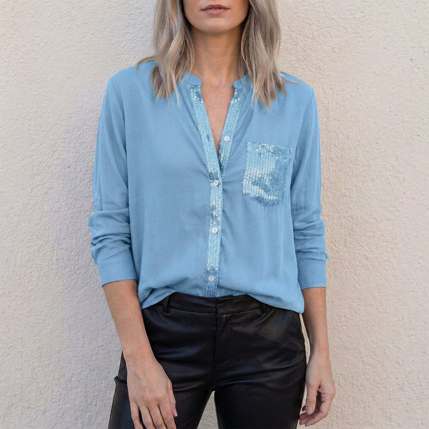 Sky blue women's summer blouse with V-neck and denim button front, by FJØRNA, showcasing a casual top for warm weather.