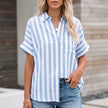 Sky blue striped linen summer blouse for women by FJØRNA, featuring a button-front casual top with short sleeves.