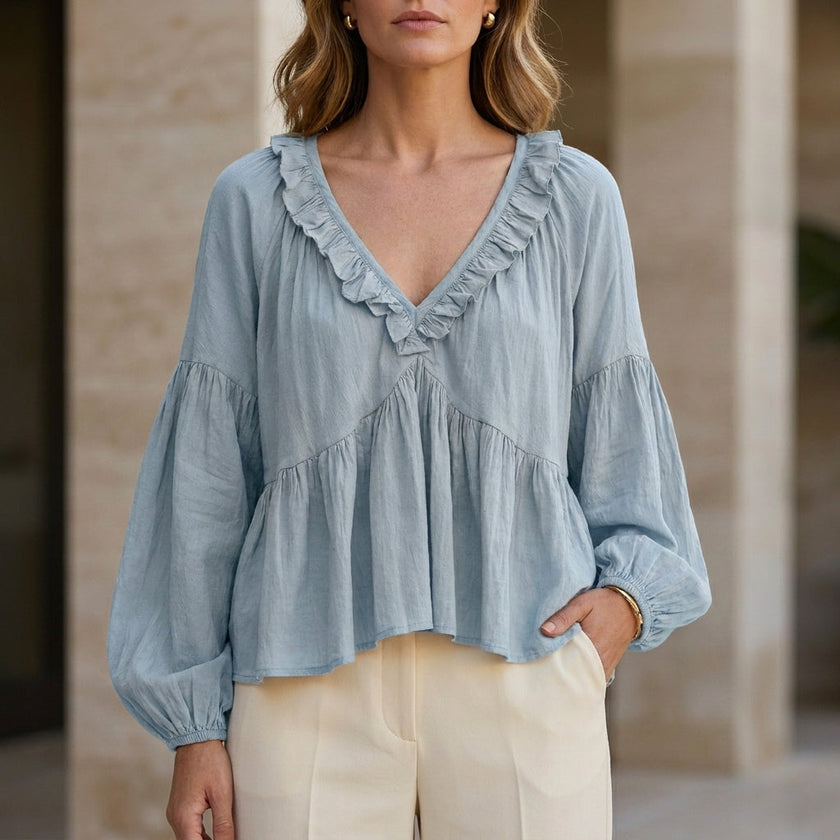 Sky blue V-neck long sleeve denim blouse for women with ruffle details by FJØRNA, styled as a summer top.