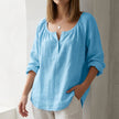 Sky blue V-neck linen summer blouse for women by FJØRNA, lightweight, flowy, and perfect for warm weather.