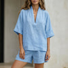 Sky blue relaxed V-neck blouse and tailored shorts set by FJØRNA, casual 2-piece outfit with soft fabric and contemporary style.