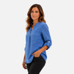 Women's elegant V-neck long sleeve blouse by FJØRNA, casual dressy top in blue, styled for a studio portrait.