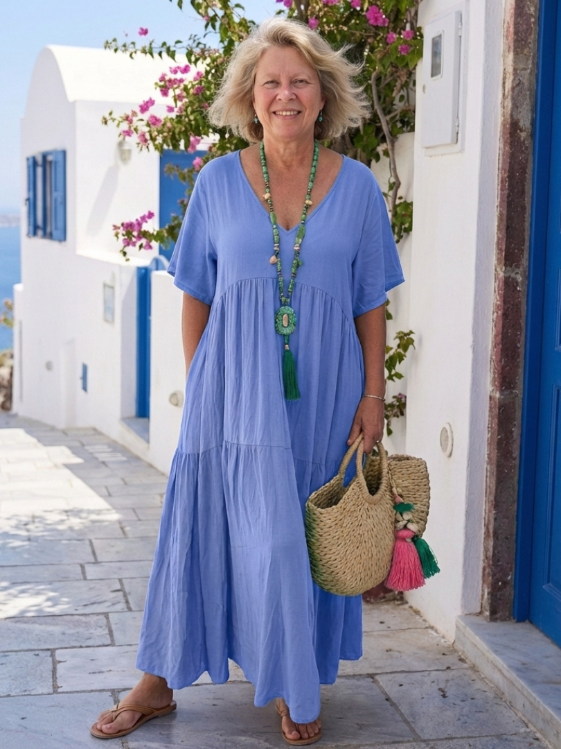 Blue FJØRNA summer maxi dress for women with short sleeves and ruffle details, featuring a tiered design and flowing silhouette.