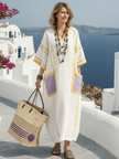 FJØRNA women's summer maxi dress with V-neck, short sleeves, and pockets, displayed on a hanger in a bright, airy setting.
