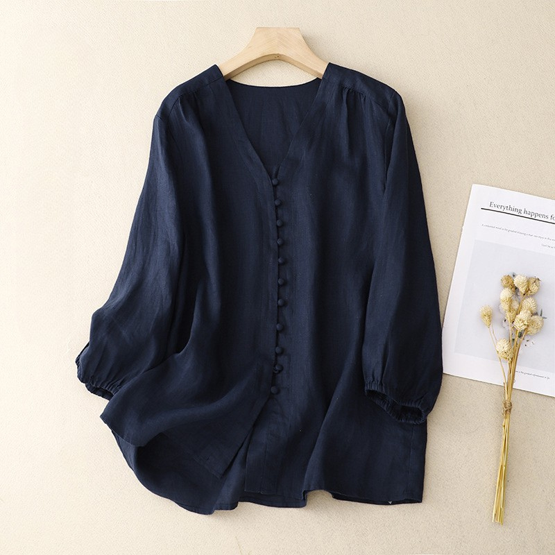 FJØRNA women's summer linen blouse with V-neck, lightweight and casual, shown in a natural fabric and relaxed fit.