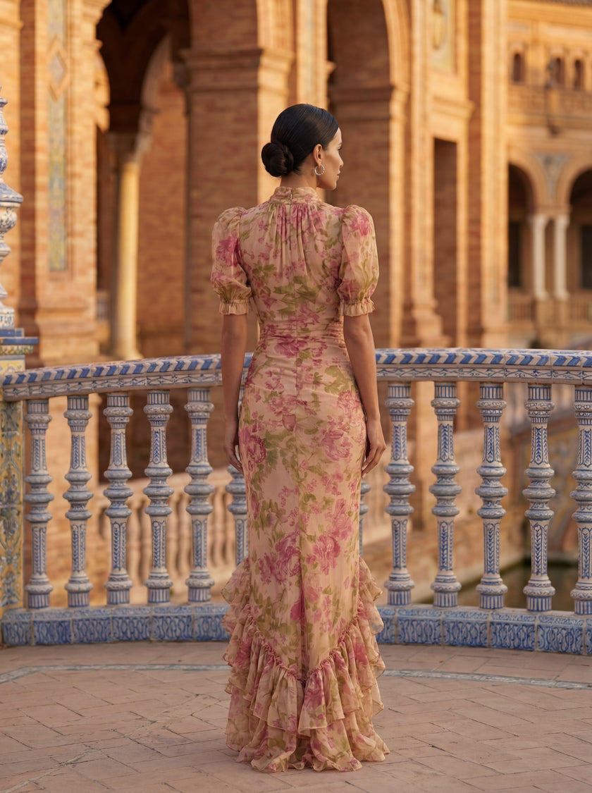 Woman wearing a floral high-neck summer dress by FJØRNA, showcasing a stylish, sleeveless design with vibrant floral patterns.