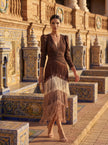 Elegant women's dress by FJØRNA featuring a V-neckline and fringe details, shown on a model wearing the stylish dress.