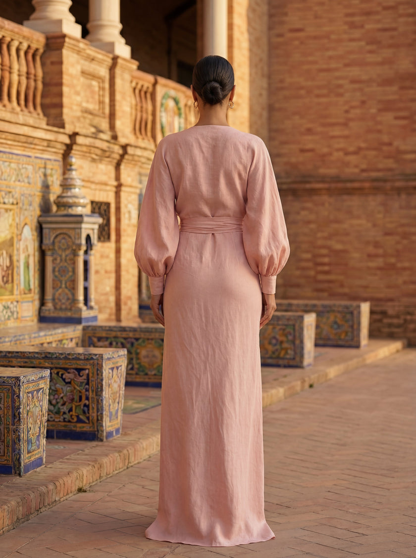 Elegant women's maxi dress by FJØRNA featuring a V-neckline and linen fabric, showcased on a woman in a stylish outdoor setting.