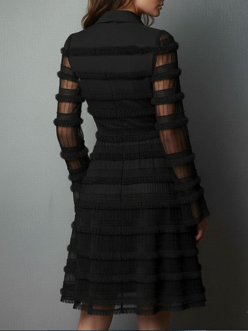 Black FJØRNA mini dress with sheer layered panels and lace details, showcasing a stylish, fitted silhouette.