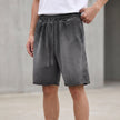 Men's casual knit shorts by FJØRNA with distressed finish, raw hem, and relaxed fit, shown in washed ash color.