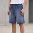 Men's washed blue FJØRNA casual knit shorts with distressed finish and raw hem, relaxed fit and comfortable style.