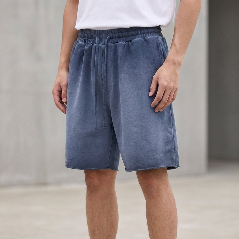 Men's washed blue FJØRNA casual knit shorts with distressed finish and raw hem, relaxed fit and comfortable style.