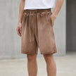 Men's relaxed knit shorts by FJØRNA with distressed finish and raw hem, shown in washed coffee color.