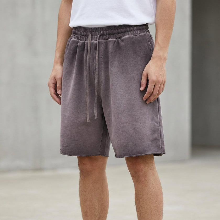 Men's casual relaxed knit shorts by FJØRNA in washed purple with distressed finish and raw hem, showcasing a comfortable, stylish design.