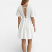 Women's white lace summer dress by FJØRNA featuring a V-neck, A-line silhouette, perfect for wedding guest occasions.