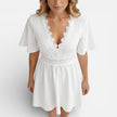 Women's white lace summer dress by FJØRNA featuring a V-neck and A-line silhouette, perfect for wedding guest attire.