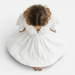 Women's white lace summer dress by FJØRNA featuring a V-neck and A-line silhouette, perfect for wedding guest attire.