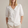 White women's summer blouse by FJØRNA with puff sleeves, linen fabric, and button front detail.