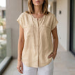 White FJØRNA women's sleeveless V-neck summer blouse, lightweight top with a stylish V-neck design.