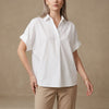 White FJØRNA summer women's blouse with short sleeves and denim fabric, featuring a loose fit and wide-leg style.