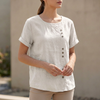 White FJØRNA summer women's blouse with short sleeves and an asymmetric linen design, ideal for warm weather.