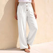 White linen summer trousers for women with button front by FJØRNA, casual and breathable for warm weather.