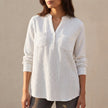 White textured button-front blouse for women with chest pockets and relaxed fit by FJØRNA, showcased on a model.