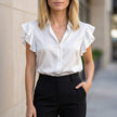 White satin ruffle summer blouse for women by FJØRNA, stylish top with feminine ruffle details and lightweight fabric.
